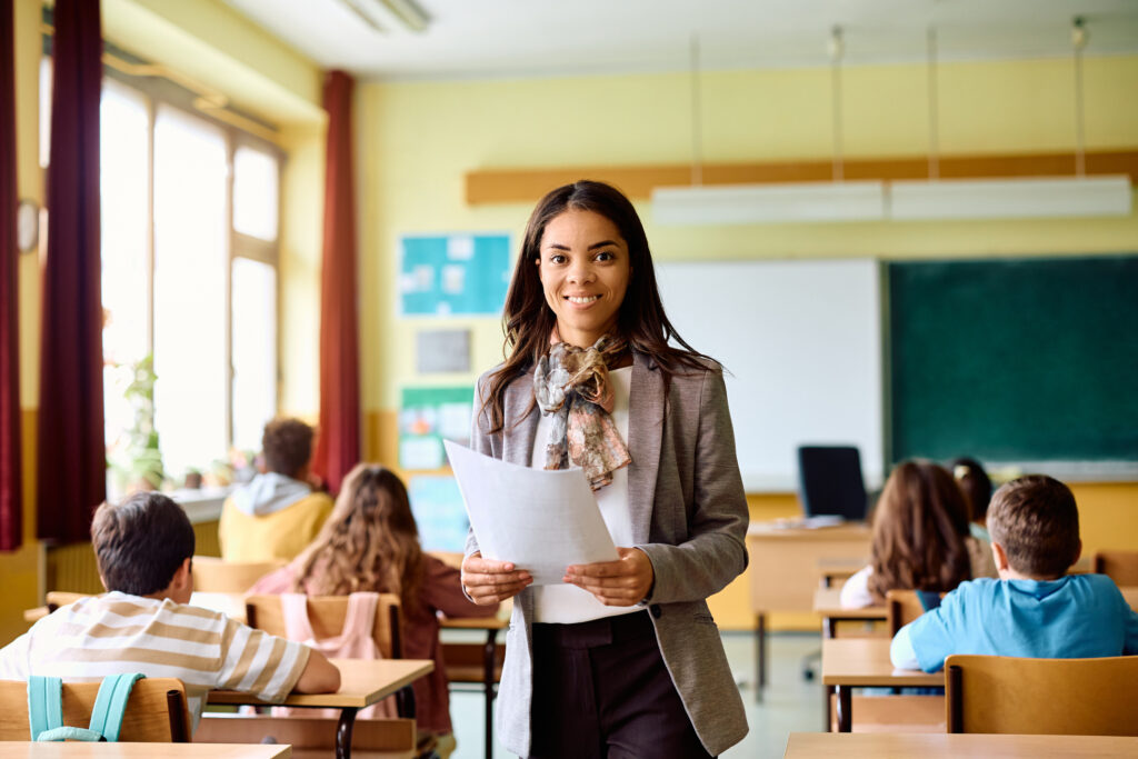 Happy Hispanic teacher during a class at elementary school looking at camera.