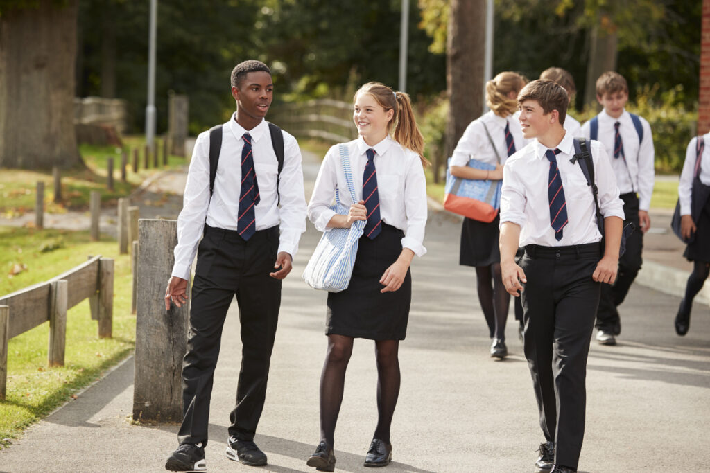 Group Of Teenage Students In Uniform Outside School Buildings

