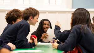 School speaker Shocka is smiling and working with students.